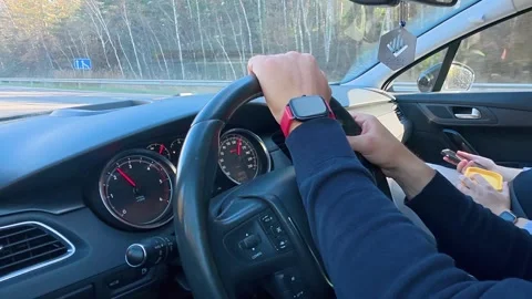 Driver Hands on Steering Wheel with Passenger Using Phone on Road Trip Stock Footage 336747702