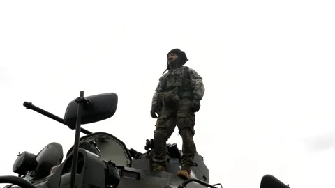 The driver in the helmet mechanic stands on the armor of the tank, APC Stock-Footage 218434376