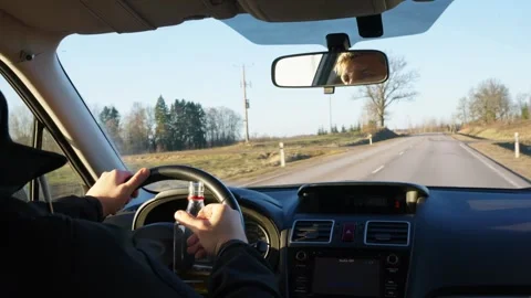 Driver Holding Bottle While Navigating Winter Road, Dangerous Reckless Act Video stock 301795727