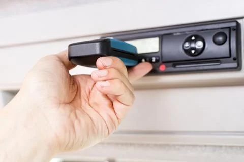 Driver holding a digital tachograph reader with isolated white screen Stock Photos