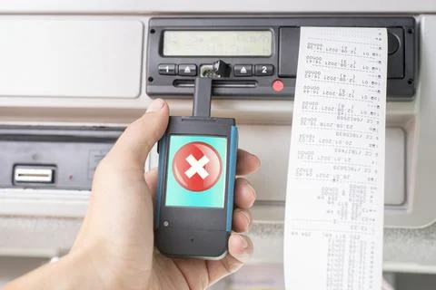Driver holding a digital tachograph reader with big red cross mark on the screen Stock Photos