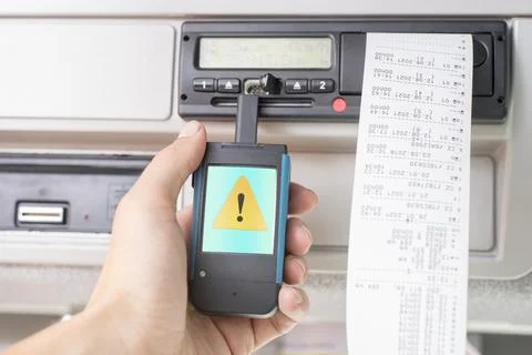 Driver holding a digital tachograph reader with an exclamation mark in a yellow Stock Photos