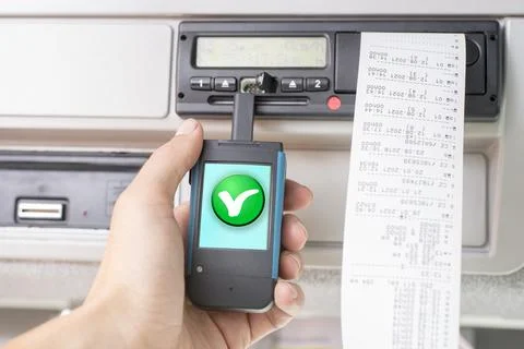 Driver holding a digital tachograph reader with a green OK check mark Stock Photos