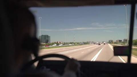 The driver is holding the steering wheel and driving a truck on the highway. Stock-Footage 82709252