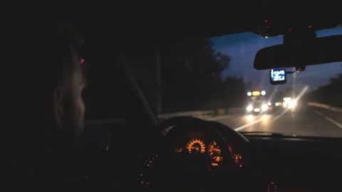 Driver holds hands on steering wheel and rides in auto on highway at night time Vidéo 320395564