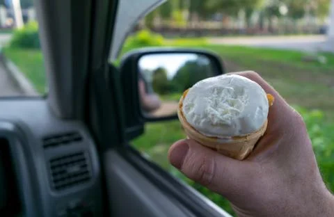 The driver holds the ice cream while driving a car Stock Photos