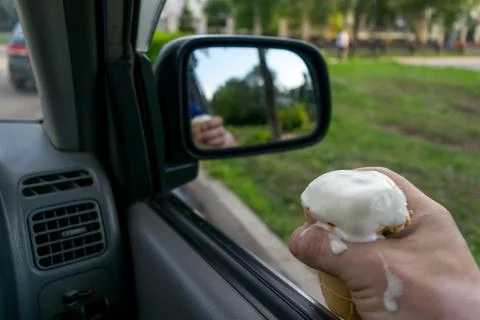 The driver holds the ice cream while driving a car Stock Photos