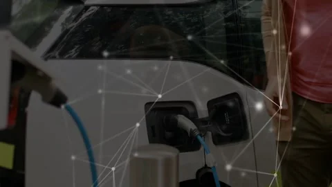 Driver inserting blue plug into EV port, checking smartwatch for charge, network Stockbeeldmateriaal 334179121