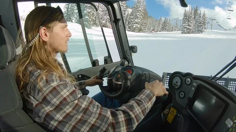 A driver inside a Piston Bully snow grooming machine at Alta, Utah. Stock Footage 99809130