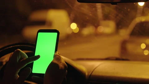 Driver Interacting with Green Screen Smartphone at Night: In-Car Chroma Key Stock Footage 282410532