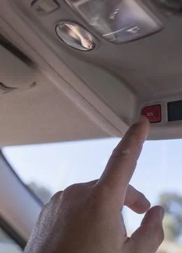 Driver just about to press SOS button while he is driving Stock Photos