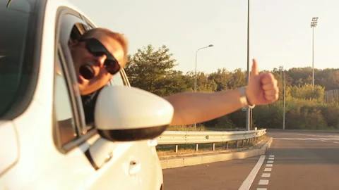 The driver leaning out of the window showing his thumb up in motion 動画素材 95533407