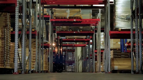 The driver on the loader moves through the warehouse along the rows Stock Footage 98266218