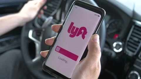 Driver Loading Lyft Ride Sharing App on a Smartphone Inside a Car Stock Footage