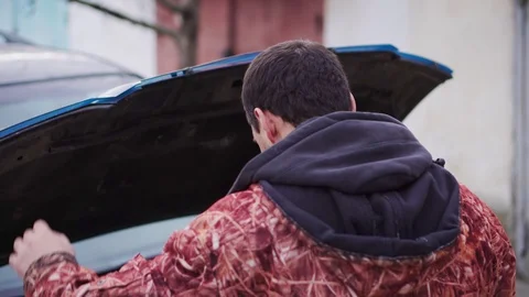 Driver looking frustrated under the hood of a car closeup Stock Footage 102177743