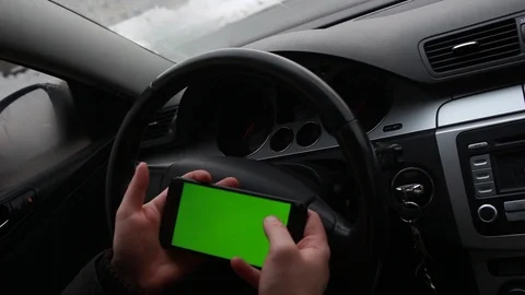 Driver looks at a map on a smartphone.  man plays a game on phone in car. Stock Footage 104826022