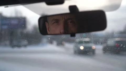 The driver looks at the passenger through the rearview mirror. Stock Footage 146463092