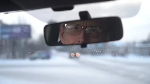 The driver looks at the passenger through the rearview mirror. Stock Footage 156049696
