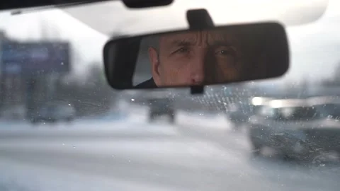 The driver looks at the passenger through the rearview mirror. Stock Footage 156998972