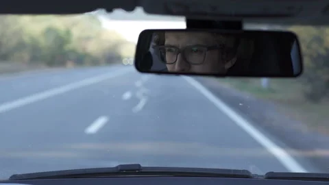 The driver looks in the rearview mirror Stock Footage 121912824