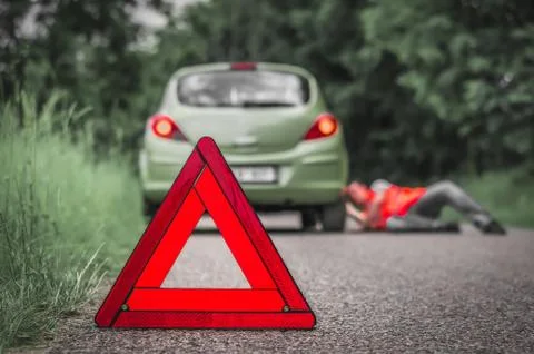 Driver lying under the broken car Stock Photos