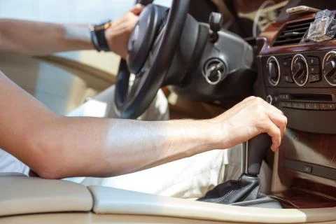 Driver man hand holding automatic transmission in car Stock Photos