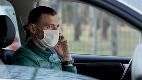 Driver in mask processes his hands with sanitizer before driving. Stock Footage 136755459