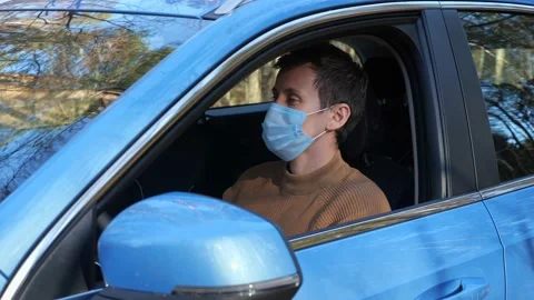 Driver in mask waits for emergency car service arrival Stock Footage 164942487