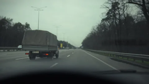 A driver navigates through dense traffic attentively observing surrounding v Stock Footage 331312634
