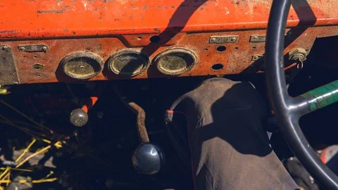 The driver of an old tractor holds his arm at the speed switch Stockbeeldmateriaal 93830537