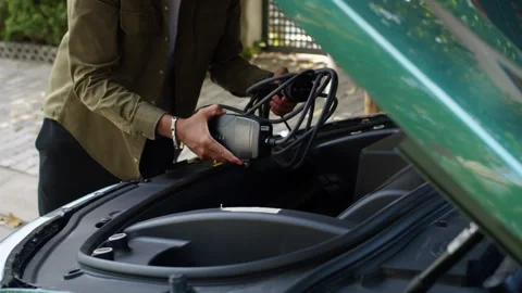Driver Opening Car Trunk to Take out Charging Cable Video stock 279534213