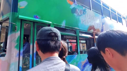 The driver opens the doors to the tram and gets out. He is wearing gloves and a Stock Footage 342332756