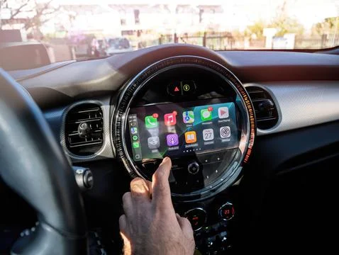 Driver Operating Apple CarPlay in MINI Electric Photos