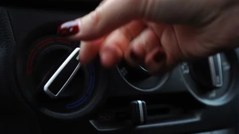 The driver or passenger hand regulates the flow of warm or cold air with a Stock Footage 165872535