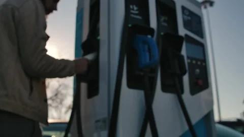 Driver is Plugging Power Supply to Electric Car for Charging Close up Stock Footage 166489098