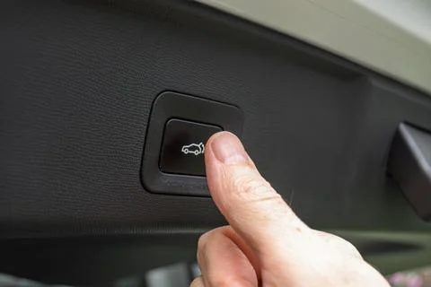 Driver presses power tailgate button inside car trunk to close liftgate, sh.. 写真素材