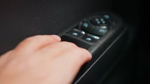 Driver presses window open and close button at the arm rest of the vehicle .. Stock Footage 293844774
