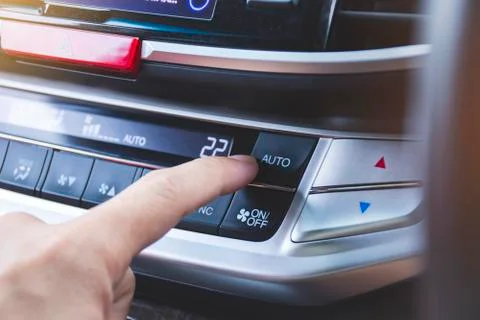 Driver pressing automatic cooling button of car air conditioner Stock Photos