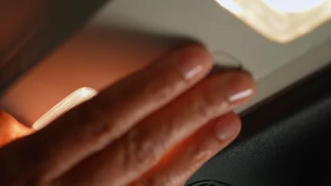 Driver pressing button to turn on and off lamp lights at the car ceiling tr.. Stock Footage 293844741