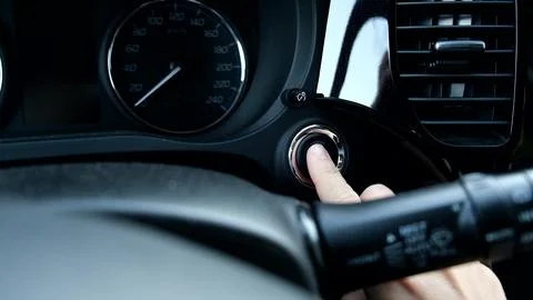 Driver pressing car engine start button in a modern car. Stock Photos