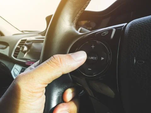 Driver pressing volume button of car radio Stock-Fotos