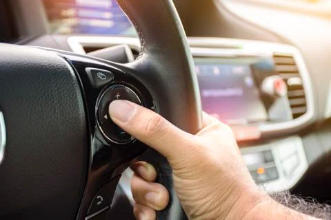 Driver pressing volume button on steering wheel Stock Photos