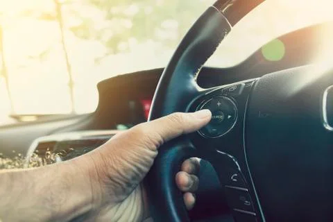 Driver pressing volume button on steering wheel Stock Photos