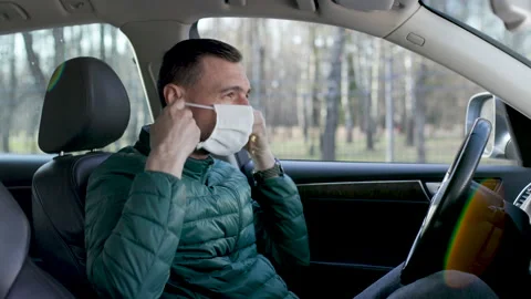 Driver processes his hands with sanitizer and puts on mask Stock Footage 136757001