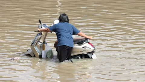 Driver pushes motorcycle through flooded street Stock Footage 341481638
