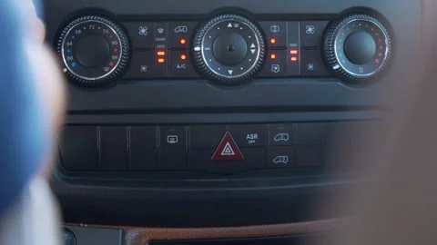 Driver pushing hazard light button on car dashboard Stock Footage 342069765