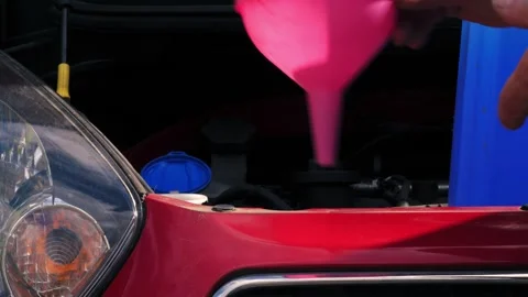 Driver putting funnel into windscreen wash tank in car 스톡 동영상 344747362