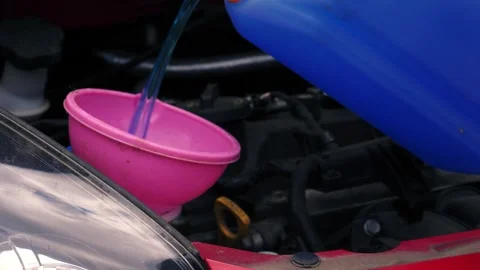 Driver putting windscreen wash fluid into car 스톡 동영상 344689726