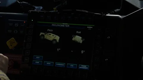 Driver reading onboard inclinometer screen on new Oshkosh JLTV Stock Footage 104601225
