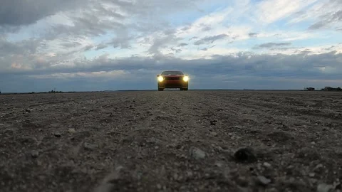 Driver On Red Dodge Challenger Drives Over Camera In The Dirt Road. - front Video stock 162737238
